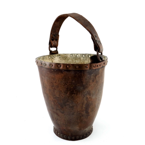 487 - A tan leather fire bucket, 19th Century, strap handle, copper rimmed and studded container with a pa... 