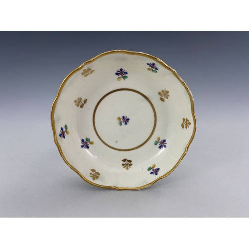 961 - A Caughley tea trio, circa 1790, reeded tea bowl and coffee cup, painted with French Sprigs in polyc... 