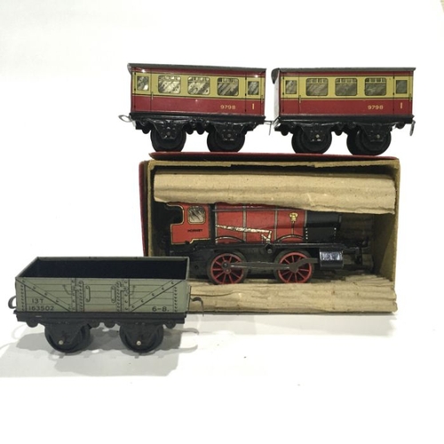 99A - A Hornby tin plate clockwork engine, Type M1, red and black liveryl boxed, together with two passeng... 