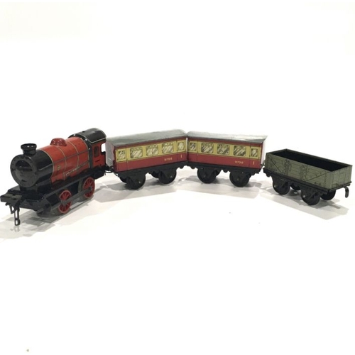 99A - A Hornby tin plate clockwork engine, Type M1, red and black liveryl boxed, together with two passeng... 