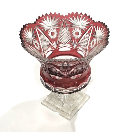 227 - A Bohemian red flashed glass pedestal vase, flared form with engraved floral and diamond cut decorat... 