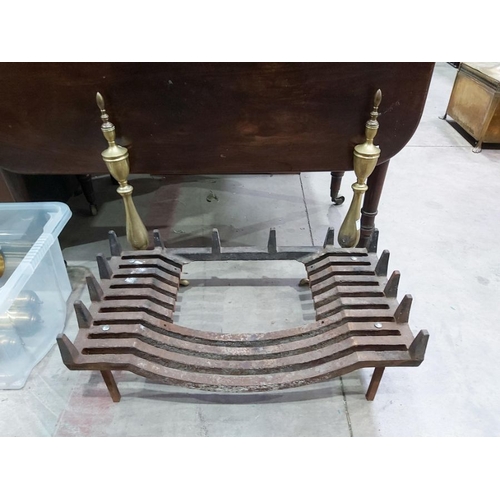 853 - A cast iron fire grate, with a pair of integral brass fire dogs