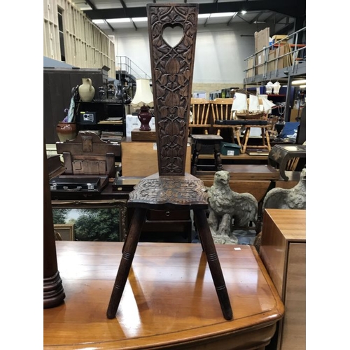 771 - A Welsh carved oak spinning stool, with pierced heart aperture, on turned splayed supports 37cm wide... 