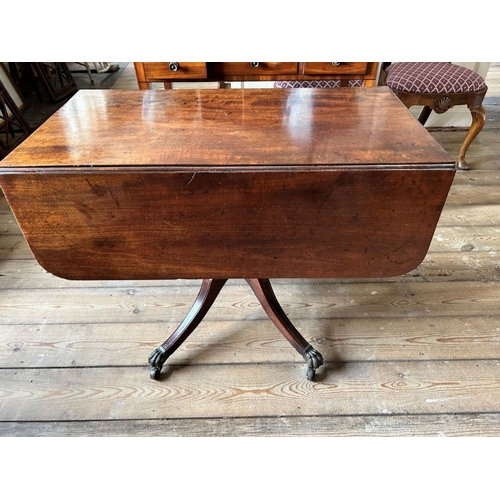 774 - A Regency mahogany Pembroke table, circa 1820, curved end flaps, sabre legs, brass paw cappings and ... 