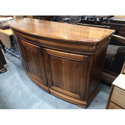 812 - A reproduction yew wood bow front sideboard, fitted three drawers over three cupboard doors, 180 cm ... 