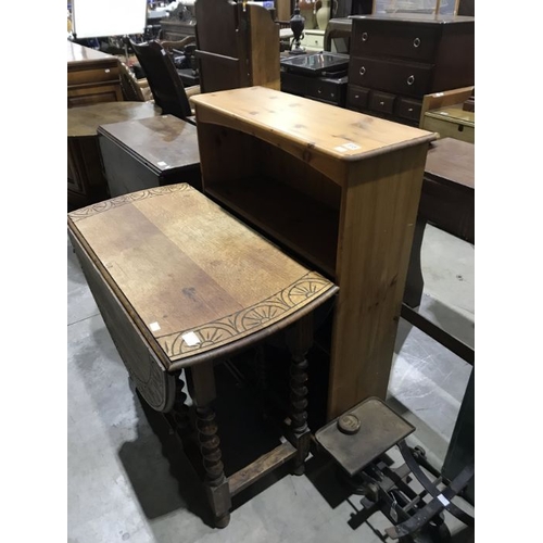 815 - An oak drop leaf gate leg table with carved stylised border, together with a set of pine bookshelves... 