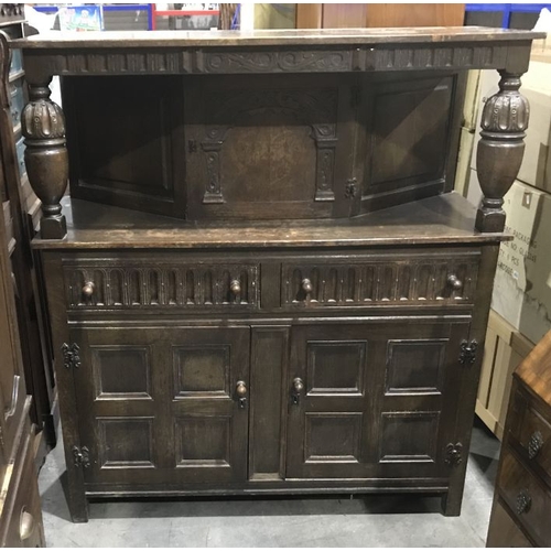 871 - A reproduction carved oak court cupboard, with single cupboard, above drawers and panelled cupboard ... 