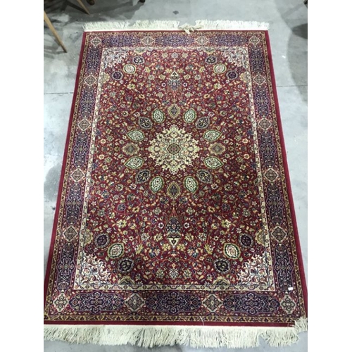 913 - An oriental red ground rug, 87 inches long, 55 inches wide