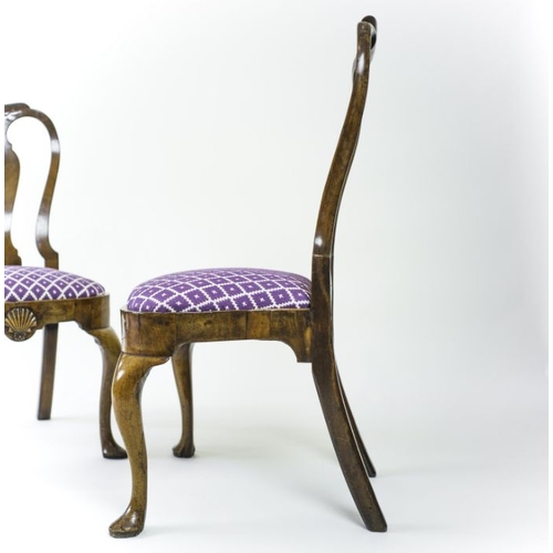 953 - A pair of early George II walnut side chairs, circa 1730, moulded top rails, pierced backs with vase... 