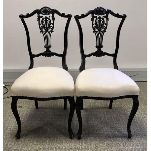 1026 - A pair of Victorian ebonised salon chairs, carved foliate lyre splat backs and shell acanthus scroll... 