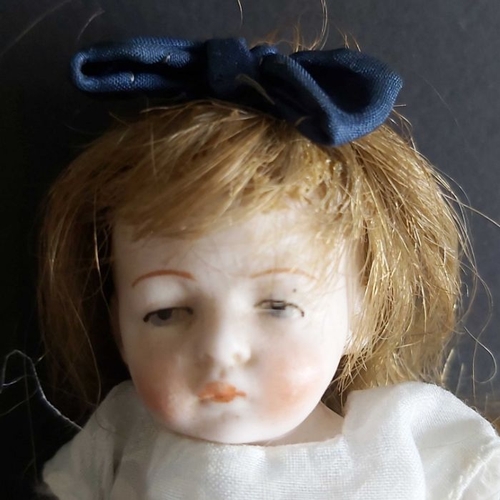 409 - A small German bisque head doll, composite jointed body, in linen and cloth dress, 12cm high