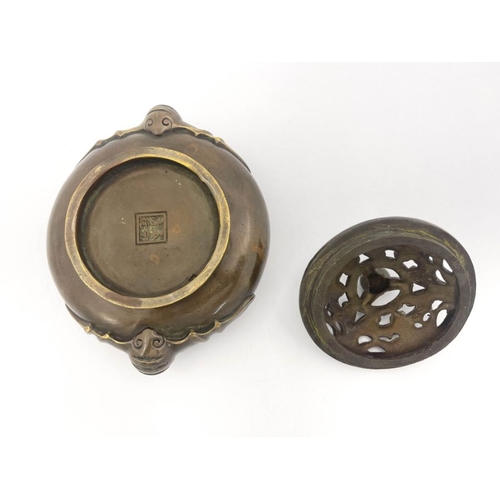 477 - A Chinese bronze censer, twin bat handles, the base bearing four character marks, pierced bronze cov... 