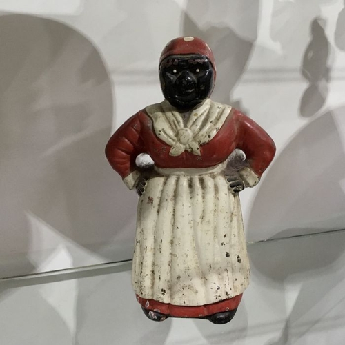 479 - A cast iron piggy bank, modelled as a 'mammy' black woman in apron