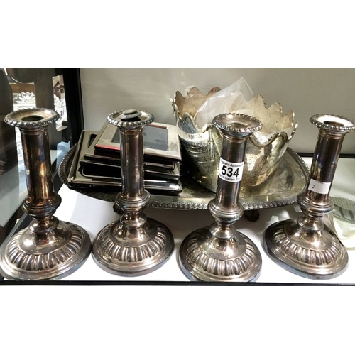 534 - A collection of plated wares including a set of four candlesticks, monteith, four  photograph frames... 