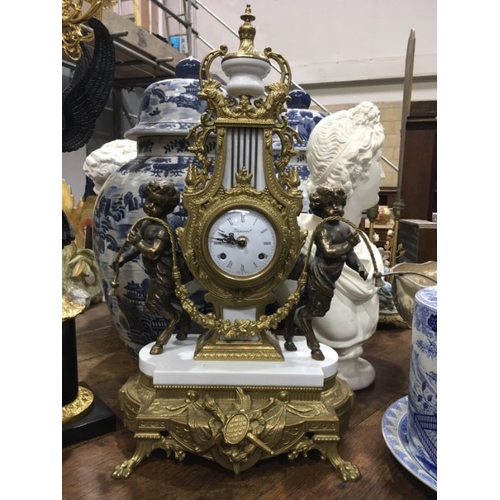 553 - An Imperial Italian gilt metal mantel clock, lyre form flanked by cherubs, on white marble base and ... 