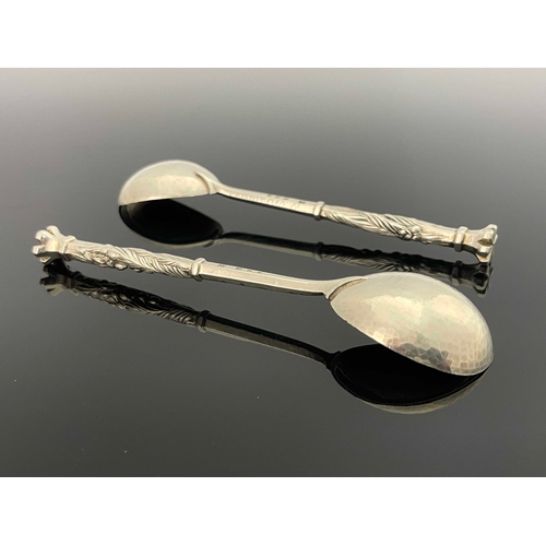 128 - Omar Ramsden, a pair of  Arts and Crafts silver spoons, London 1932, planished, hexagonal stems with... 