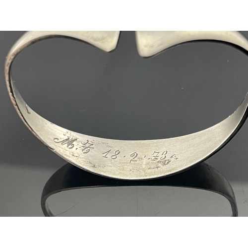 186 - A Modernist silver bangle, circa 1972, stylised torque form with axe head ends, 6.5cm wide, 0.92ozt