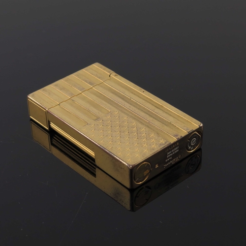 191 - S T Dupont, a gold plated American Flag lighter, relief moulded stars and stripes to each side, 6cm ... 