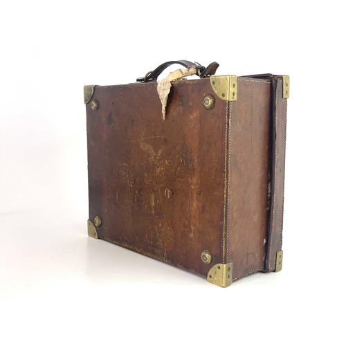 214 - A late 19th or early 20th century leather gun cartridge case, brass corner guards, secure lever lock... 