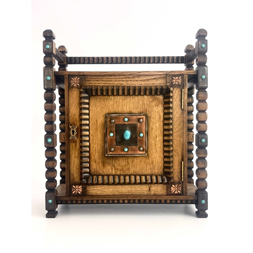 250 - An Arts and Crafts oak smoker's compendium, circa 1910, carved frame, single door with turquoise cab... 