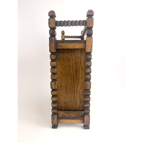 250 - An Arts and Crafts oak smoker's compendium, circa 1910, carved frame, single door with turquoise cab... 