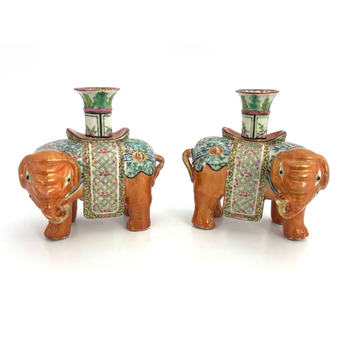 442 - A pair of 19th Century Canton famille rose standing elephant candle holders, looking to the right an... 