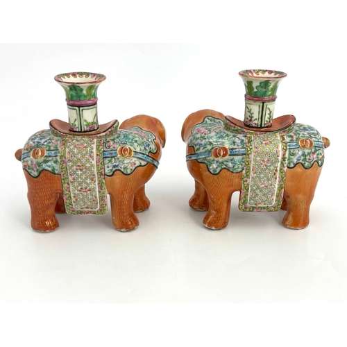 442 - A pair of 19th Century Canton famille rose standing elephant candle holders, looking to the right an... 