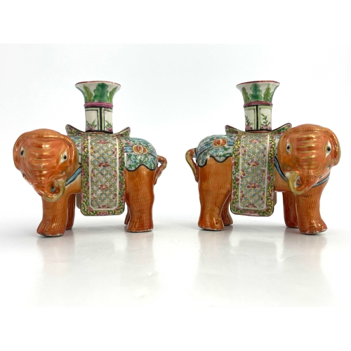 442 - A pair of 19th Century Canton famille rose standing elephant candle holders, looking to the right an... 