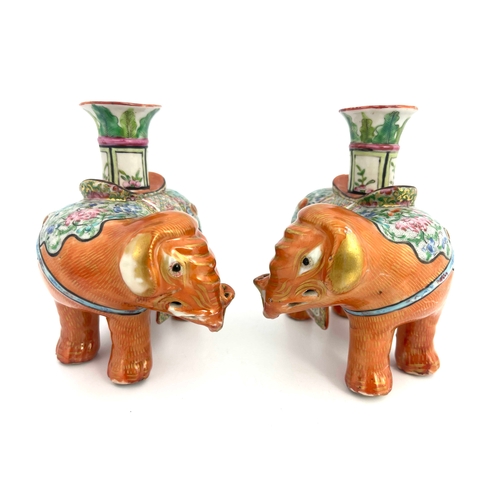 442 - A pair of 19th Century Canton famille rose standing elephant candle holders, looking to the right an... 