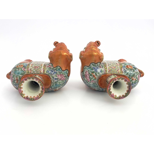 442 - A pair of 19th Century Canton famille rose standing elephant candle holders, looking to the right an... 