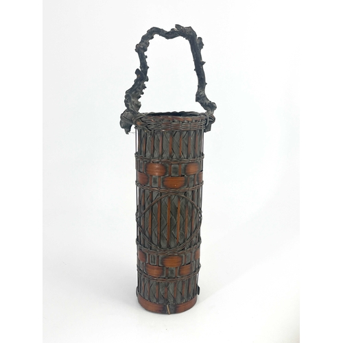 451 - A Japanese tall handled bamboo basket, cylindrical form, woven and banded body, branch carrying hand... 