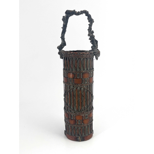 451 - A Japanese tall handled bamboo basket, cylindrical form, woven and banded body, branch carrying hand... 