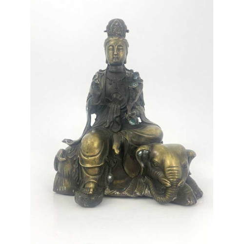 452 - A cast bronze figure of Guan Yin, modelled seated on a recumbent elephant, impressed seal mark, 28cm... 