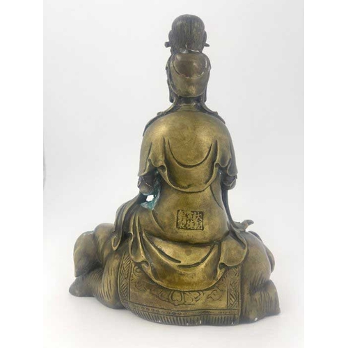 452 - A cast bronze figure of Guan Yin, modelled seated on a recumbent elephant, impressed seal mark, 28cm... 