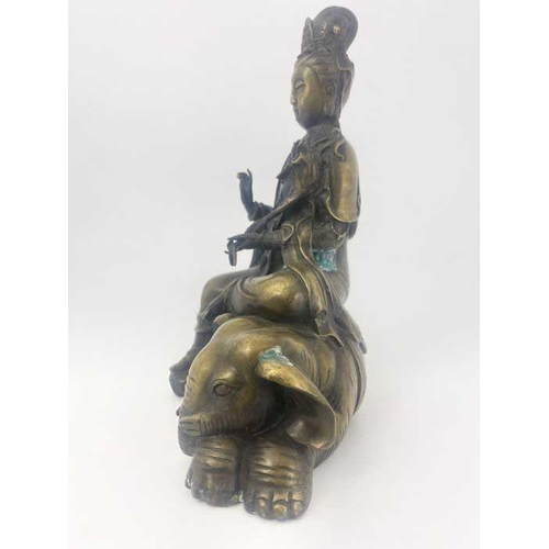 452 - A cast bronze figure of Guan Yin, modelled seated on a recumbent elephant, impressed seal mark, 28cm... 