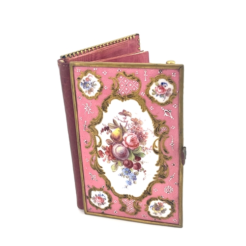 469 - A Limoges enamelled aide memoire, the cover panels painted with raised gilt Rococo scroll cartouches... 