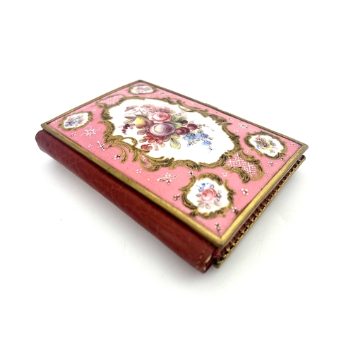 469 - A Limoges enamelled aide memoire, the cover panels painted with raised gilt Rococo scroll cartouches... 