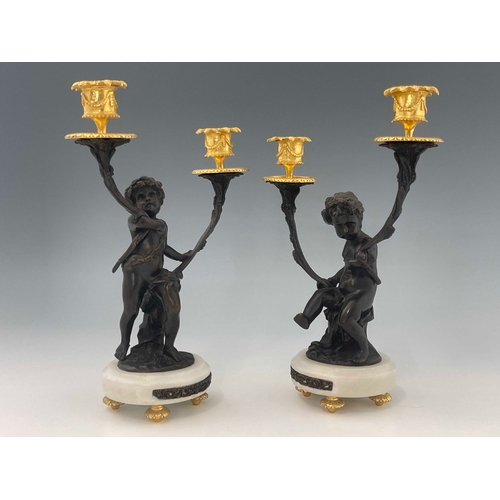 472 - A pair of French bronze double branch candelabra, late 19th Century, in the form of cherubs, gilt me... 