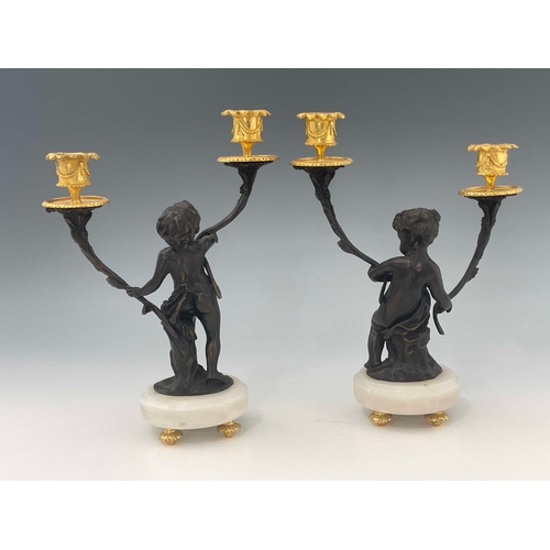 472 - A pair of French bronze double branch candelabra, late 19th Century, in the form of cherubs, gilt me... 