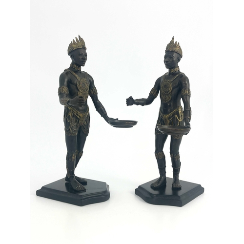 514 - A pair of bronze Nubian warrior figures, modelled wearing crowns and holding trays, highlighted in g... 