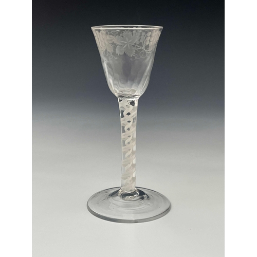 568 - An opaque twist wine glass, circa 1765, the half fluted round funnel bowl engraved with fruiting gra... 