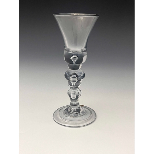 577 - A composite stem wine glass, circa 1755, the round funnel bowl on a multi spiral airtwist inverse ba... 