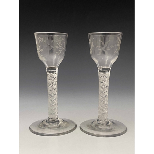 591 - A pair of air twist wine glasses, circa 1765, the ogee bowls engraved with floral sprigs, on multi s... 