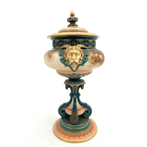 772 - A Hadleys Worcester pedestal vase and cover, modelled with twin horned mask handles, painted with mo... 