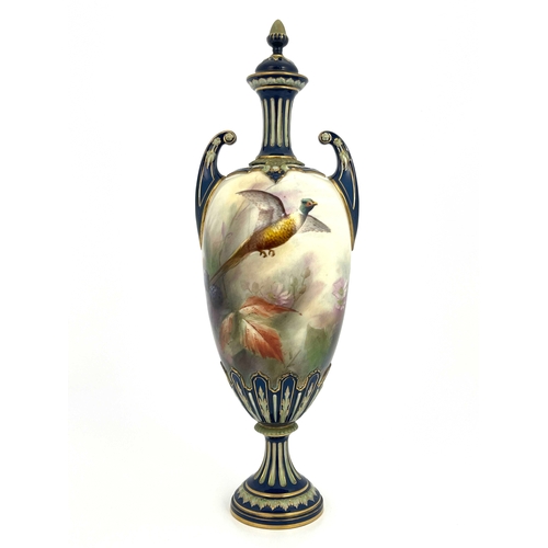 773 - A Hadleys Worcester twin handled vase and cover, relief moulded pedestal urn form, painted with a ph... 