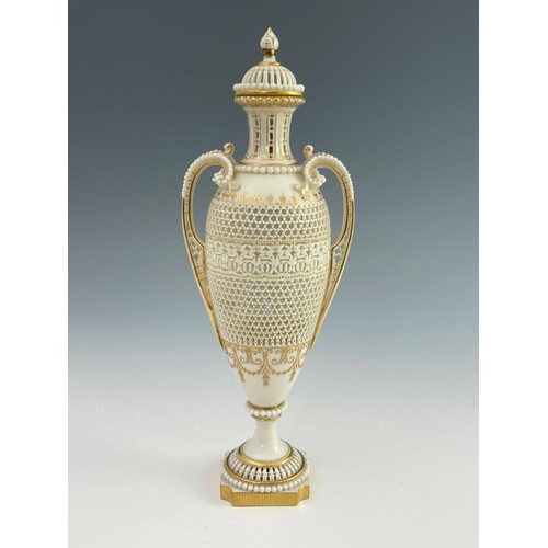 810 - George Owen for Royal Worcester, a reticulated twin handled pedestal vase and cover, 1911, elongated... 