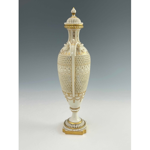 810 - George Owen for Royal Worcester, a reticulated twin handled pedestal vase and cover, 1911, elongated... 