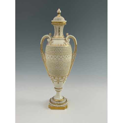 810 - George Owen for Royal Worcester, a reticulated twin handled pedestal vase and cover, 1911, elongated... 