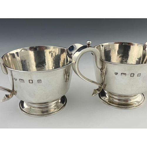 18 - A pair of Elizabeth II silver jugs, in the Charles II style, footed conical form, ear handles, 18.5m... 