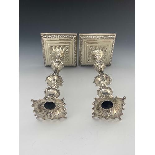 56 - A pair of George III cast silver candlesticks, Ebenezer Coker, London 1770, stepped square section b... 